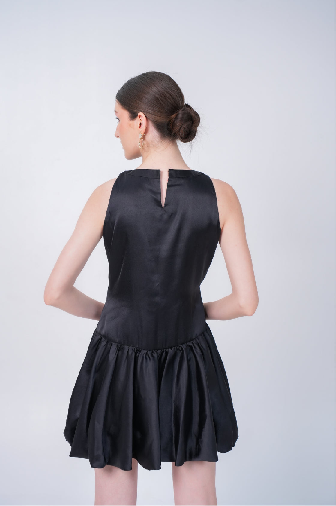 Black mini dress worn by a model on a white background